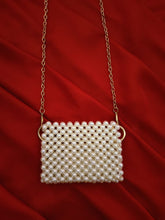Close-up of a handcrafted mini off-white beaded pouch with intricate beadwork patterns