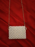 Close-up of a handcrafted mini off-white beaded pouch with intricate beadwork patterns