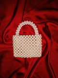 Handmade beaded tote with a crossbody strap, showcasing the precision of white and green bead designs