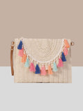 Hand-woven wicker fringe vintage bag in multi-color and off-white shades. Features a long strap for cross-body wear and a shorter strap for shoulder carry. The bag showcases intricate handmade design, combining aesthetic and cultural elements