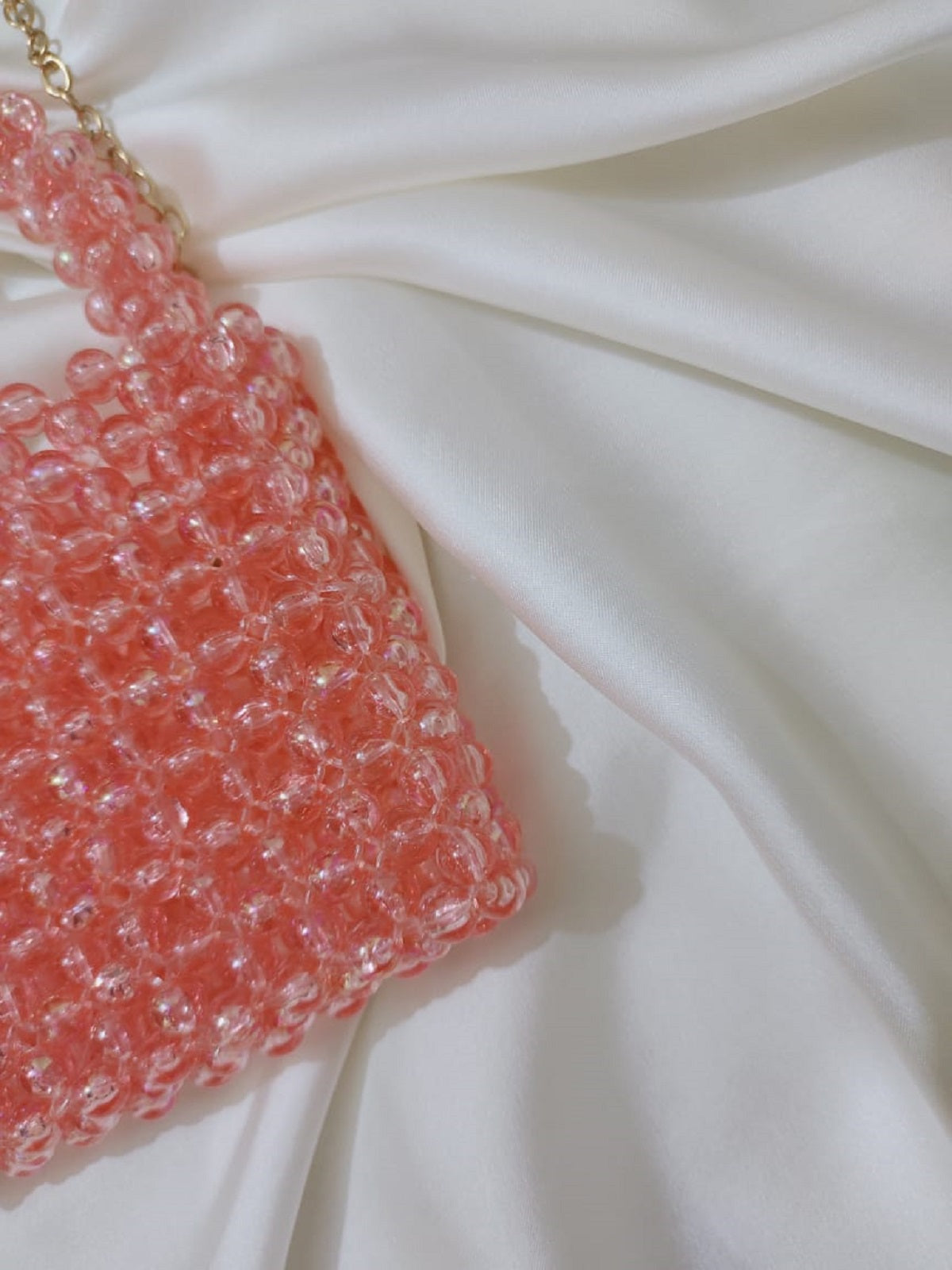 Detail shot of the mini beaded strap, crafted with matching baby pink beads, harmonizing perfectly with the bag's exterior