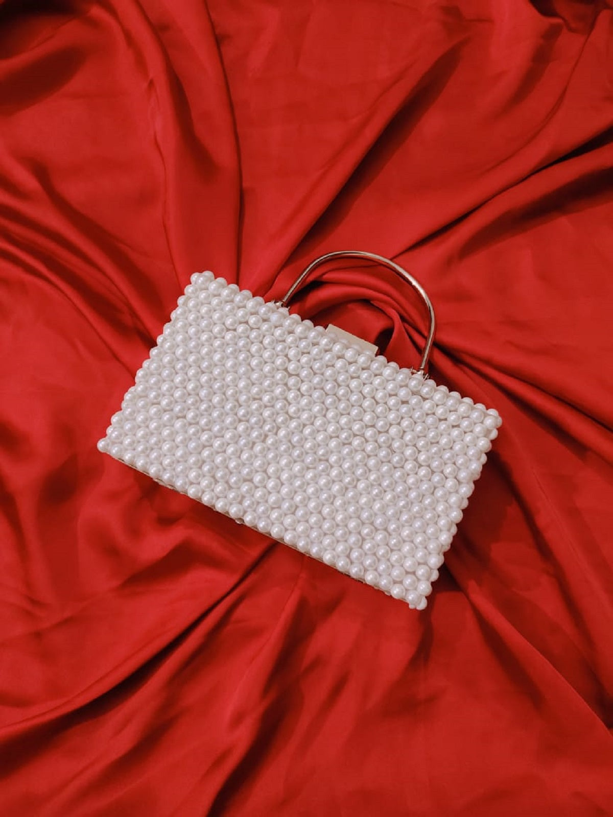 Elegant off-white pouch intricately adorned with shimmering beads, showcasing masterful craftsmanship and timeless design