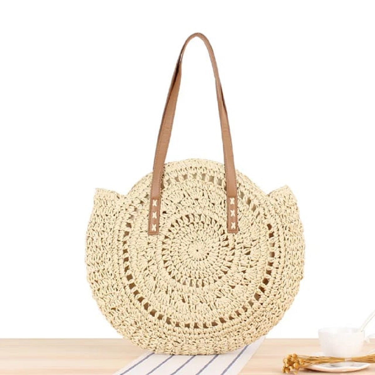 Large bohemian-style tote bag, handwoven from sustainable paper straw, featuring a round shape and inspired by Bali beach aesthetics